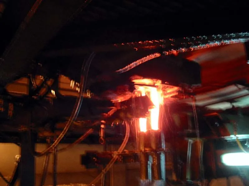 Besleyicinin altında çift damla (double gob). Fotoğraf hareketli ve düşük çözünürlüklü.